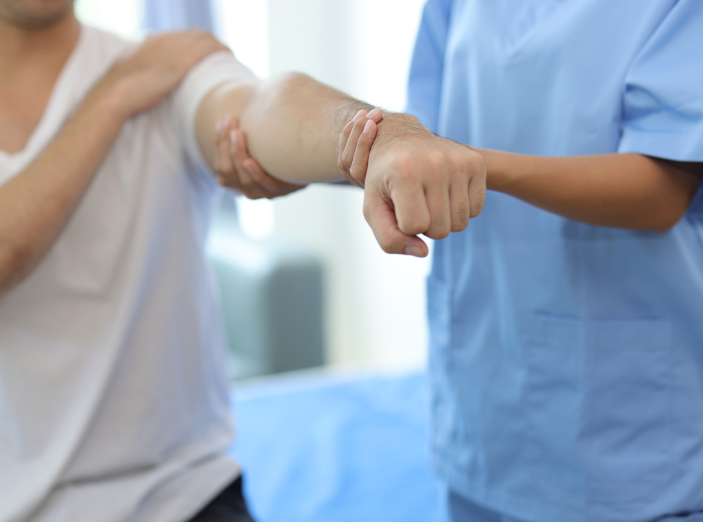 Fisioterapeuta realizando movilización y tratamiento manual especializado en el brazo de un paciente durante una sesión de fisioterapia manual especializada en el Centro Médico de Rehabilitación Majadahonda.